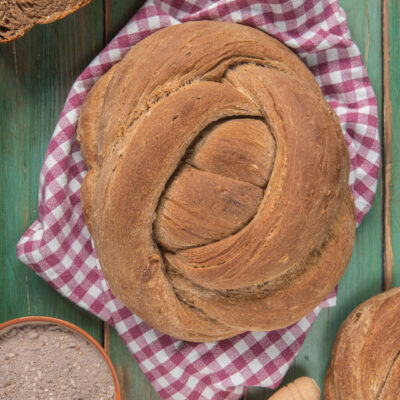 Corona di pane ai cereali intrecciata con crosta rustica e mollica alveolata a fette