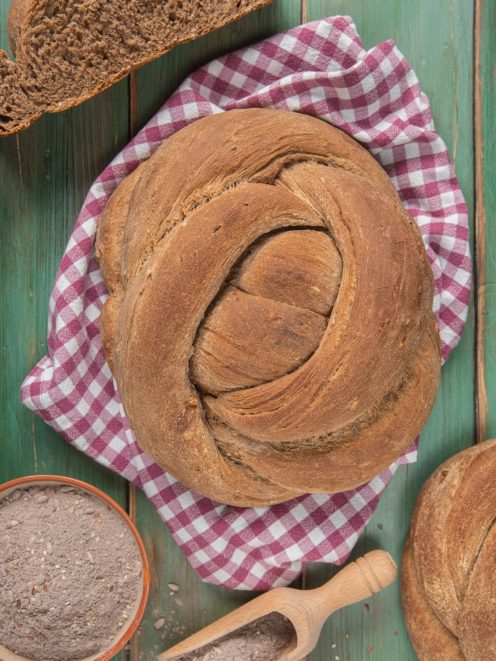 Corona di pane ai cereali intrecciata con crosta rustica e mollica alveolata a fette