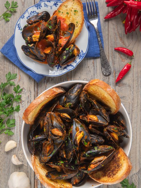 Cozze alla tarantina in salsa di pomodoro piccante con crostoni di pane e prezzemolo fresco