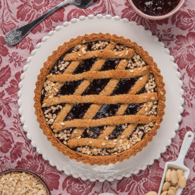 Crostata ai fiocchi d'avena e frutti di bosco con grata di pasta frolla e bordo cosparso di avena