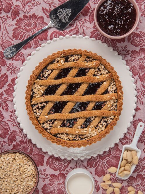 Crostata ai fiocchi d'avena e frutti di bosco con grata di pasta frolla e bordo cosparso di avena