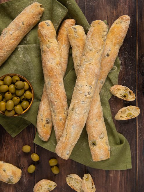 Filloncini alle olive appena sfornati con crosta dorata, alcuni tagliati a mostrare la mollica