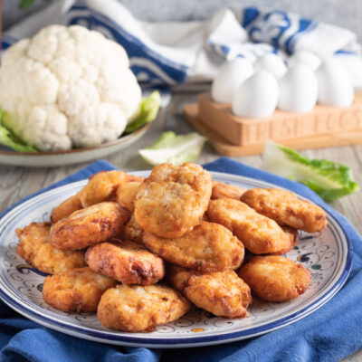 Frittelle di cavolfiore fritte e dorate, impilate e servite in abbondanza