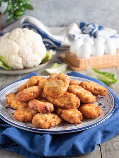 Frittelle di cavolfiore fritte e dorate, impilate e servite in abbondanza
