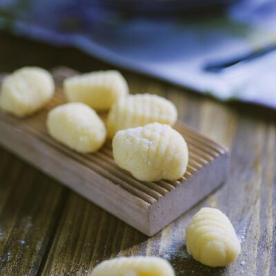 Gnocchi di semolino freschi rigati appoggiati su un rigagnocchi di legno infarinato