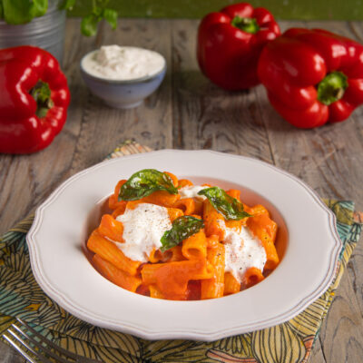 Pasta alla crema di peperoni con cucchiaiate di stracciatella e foglie di basilico fritto