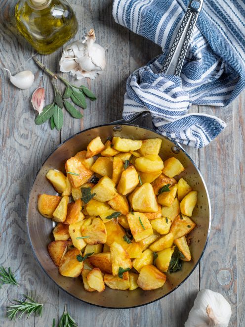 Patate in padella dorate con foglie di salvia e rosmarino
