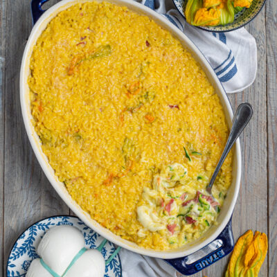 Riso al forno con zucchine, mozzarella e prosciutto, servito in teglia con la crosticina dorata