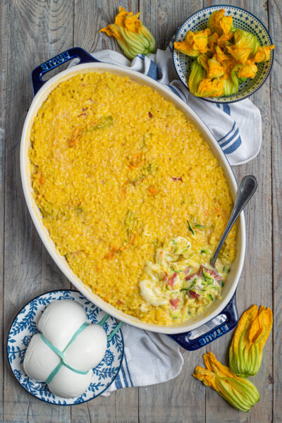 Riso al forno con zucchine, mozzarella e prosciutto, servito in teglia con la crosticina dorata