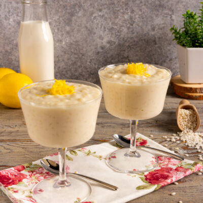 Crema di riso al latte servita in coppe con scorza di limone grattugiata