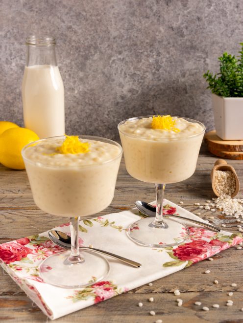 Crema di riso al latte servita in coppe con scorza di limone grattugiata