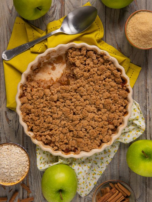 Crumble di mele appena sfornato con copertura croccante di frolla in una teglia rotonda