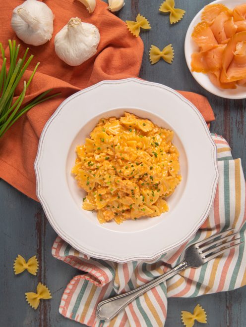 Farfalle al salmone con salsa cremosa arancione e erba cipollina tritata