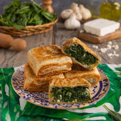 Gozleme con spinaci e feta tagliato a metà, con il ripieno verde ben visibile