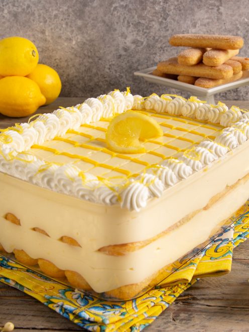 Tiramisù al limoncello con strati di savoiardi, crema al limone, ciuffi di panna e scorza grattugiata