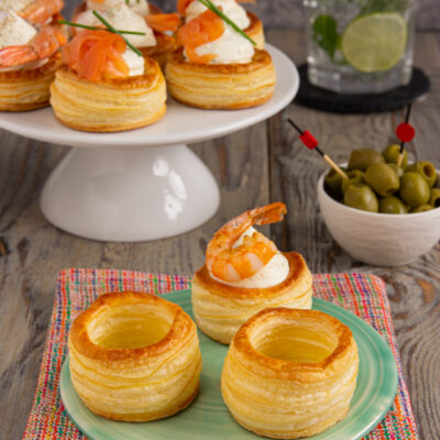 Vol-au-vent di pasta sfoglia farciti con salmone affumicato, gamberetti e crema, guarniti con erba cipollina