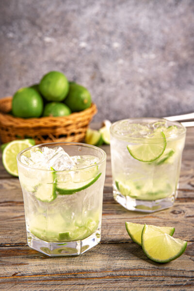 Caipirinha con ghiaccio tritato e fette di lime in due bicchieri