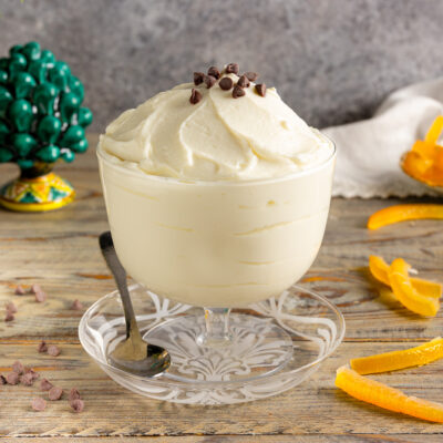 Crema di ricotta soffice servita in coppa, guarnita con gocce di cioccolato