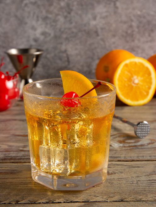Old Fashioned con ghiaccio, guarnito da una fetta d'arancia e una ciliegia al maraschino