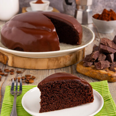 Torta brasiliana ricoperta di glassa al cioccolato lucida con una fetta tagliata a mostrare l'interno soffice