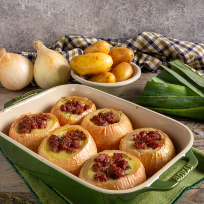 Cipolle al forno con crema di patate e cotechino.