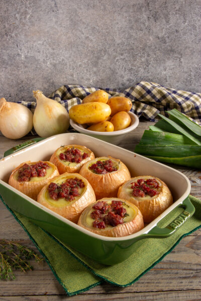Cipolle al forno con crema di patate e cotechino.