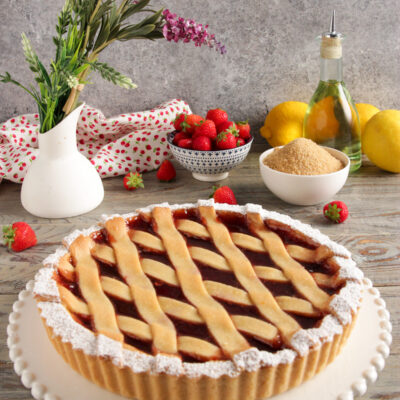 Crostata vegana con confettura di fragole, griglia di pasta frolla e zucchero a velo