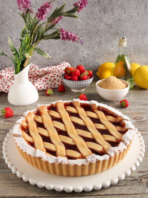 Crostata vegana con confettura di fragole, griglia di pasta frolla e zucchero a velo