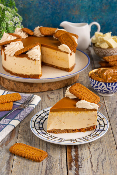 Torta Lotus con base di biscotti, crema al caramello e ciuffi di panna, una fetta servita in primo piano