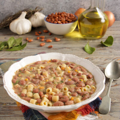 Minestra di fagioli con ditalini in brodo denso, guarnita con prezzemolo tritato