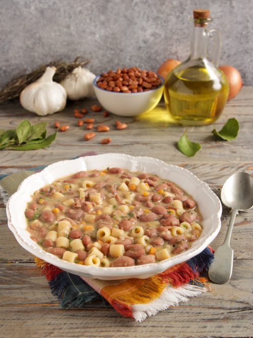 Minestra di fagioli con ditalini in brodo denso, guarnita con prezzemolo tritato