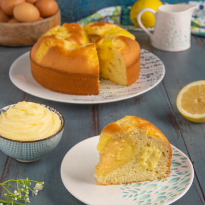 Torta Nua con ripieno di crema pasticcera al limone, una fetta in primo piano mostra il cuore morbido