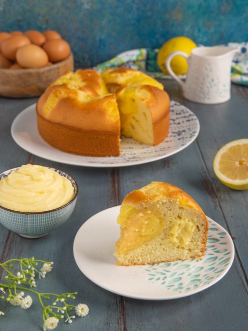 Torta Nua con ripieno di crema pasticcera al limone, una fetta in primo piano mostra il cuore morbido