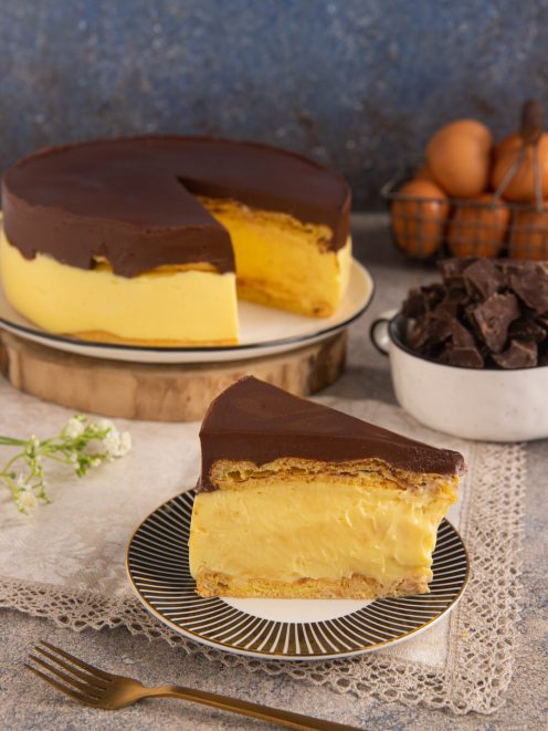 Torta eclair a fette con strati di crema pasticcera, pasta sfoglia e copertura di ganache al cioccolato
