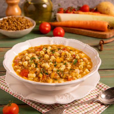 Minestra di lenticchie con ditalini, pomodoro e prezzemolo fresco in brodo denso