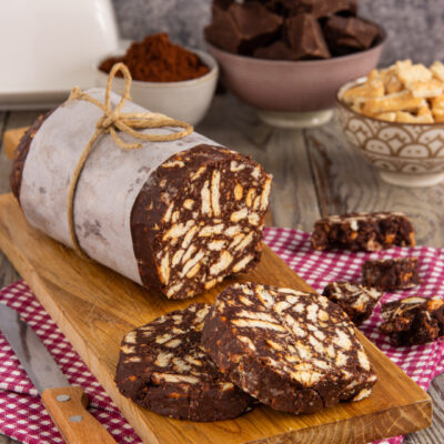 Salame di cioccolato senza uova affettato, con biscotti a pezzi ben visibili nell'impasto scuro