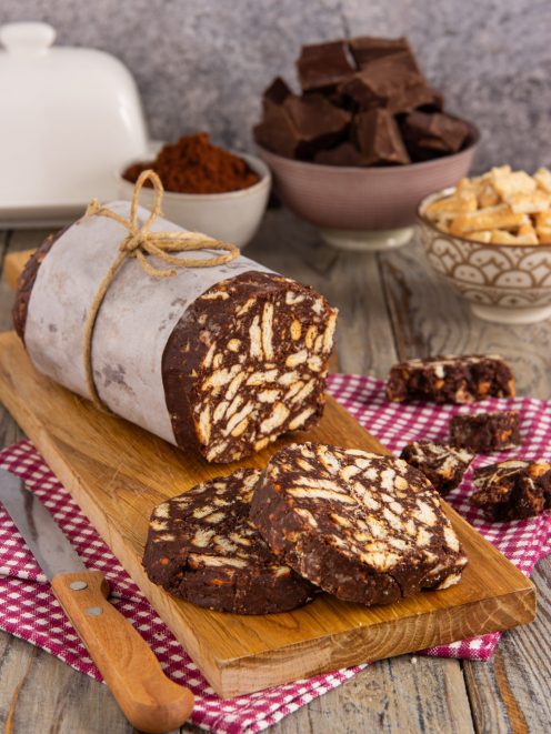 Salame di cioccolato senza uova affettato, con biscotti a pezzi ben visibili nell'impasto scuro