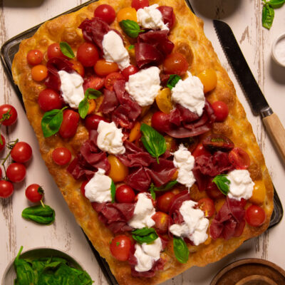 Focaccia con bresaola, pomodorini rossi e gialli, stracciatella e foglie di basilico fresco