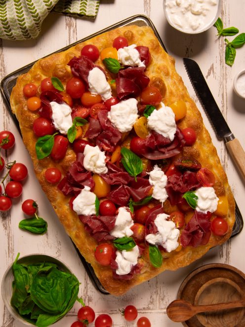Focaccia con bresaola, pomodorini rossi e gialli, stracciatella e foglie di basilico fresco