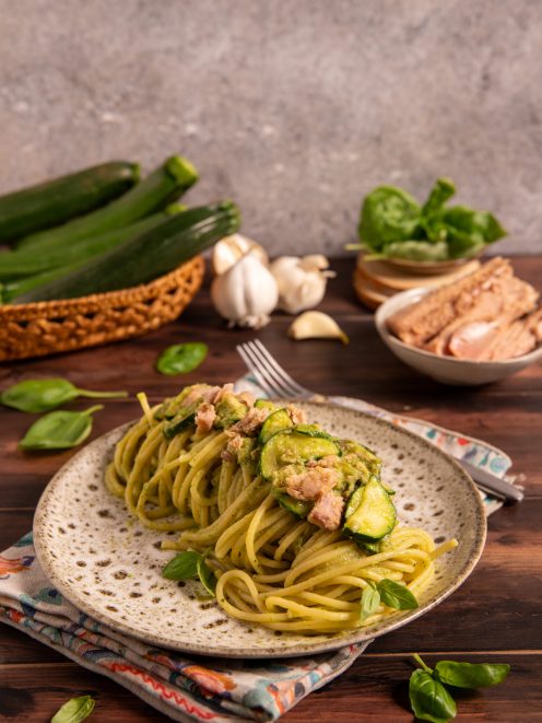 Pasta tonno e zucchine con crema verde, fettine di zucchina e pezzi di tonno, guarnita con foglie di basilico