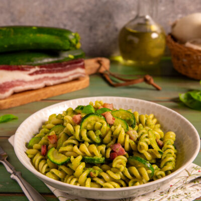 Pasta zucchine e pancetta con fusilli al pesto di zucchine, rondelle saltate e cubetti di pancetta