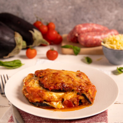 Pasticcio di melanzane gratinato con ragù, mozzarella filante e salsa di pomodoro