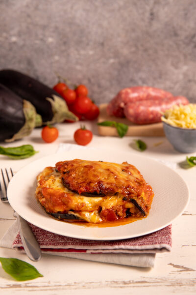 Pasticcio di melanzane gratinato con ragù, mozzarella filante e salsa di pomodoro