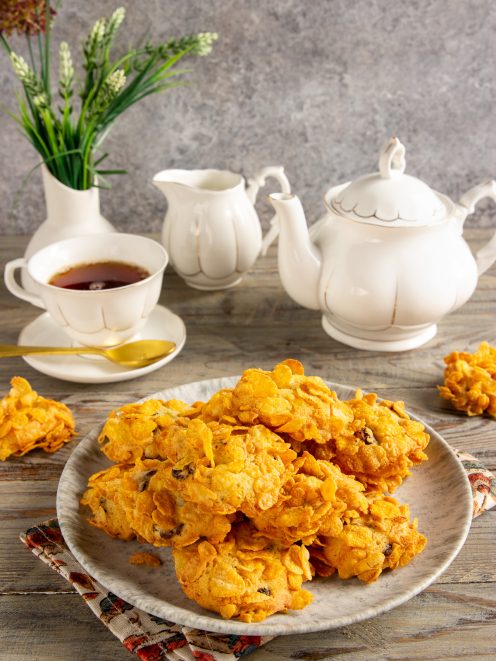 Rose del deserto ai cornflakes croccanti impilate su un piatto accanto a una tazza di tè