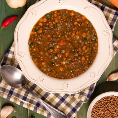 Zuppa di lenticchie con carote, pomodoro e prezzemolo in brodo saporito