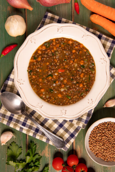 Zuppa di lenticchie con carote, pomodoro e prezzemolo in brodo saporito