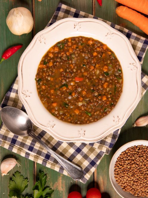 Zuppa di lenticchie con carote, pomodoro e prezzemolo in brodo saporito