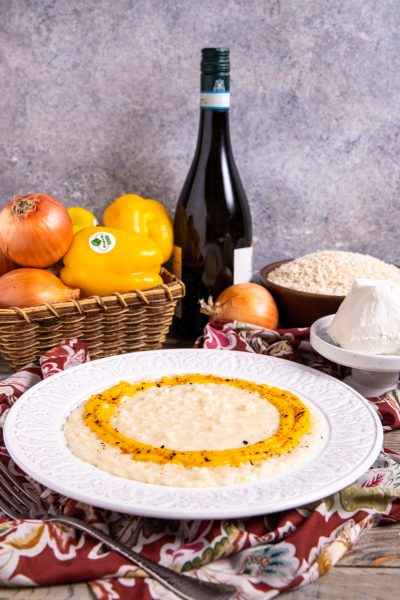 Risotto con caprino cremoso circondato da un anello di crema di peperoni arrostiti e scaglie piccanti