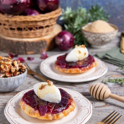 Mini tarte tatin di cipolle rosse caramellate con quenelle di formaggio fresco e noci
