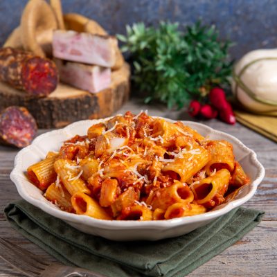 Rigatoni alla silana conditi con sugo di pomodoro e salsiccia, spolverati di formaggio grattugiato